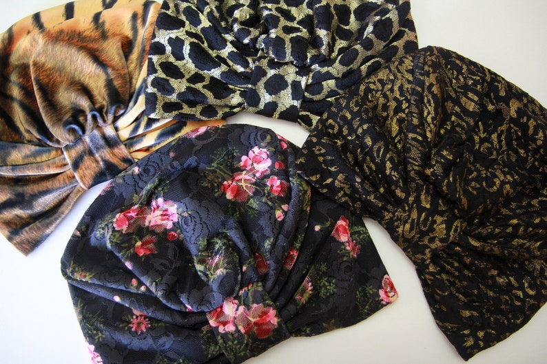 Puede incluir: Cuatro diademas de tela diferentes en una variedad de patrones. Una diadema es negra con un patr&oacute;n floral, otra es negra con un estampado de leopardo dorado, otra es negra con un estampado de leopardo dorado y negro, y la &uacute;ltima es marr&oacute;n y naranja con un estampado de tigre.