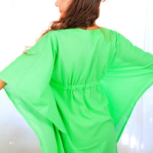 May include: A bright green, lightweight kaftan with a drawstring waist. The kaftan is made of a soft, flowing fabric and has a relaxed fit.