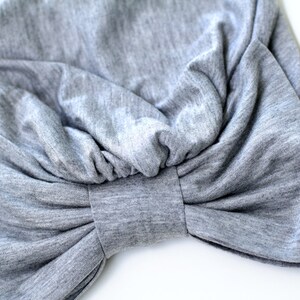May include: A gray fabric turban with a large bow in the front.