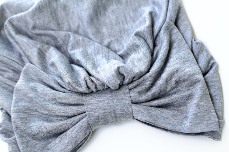 May include: A gray fabric turban with a large bow in the front.