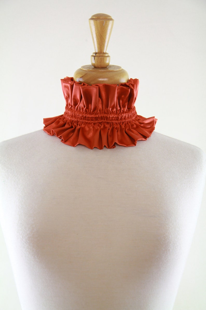 May include: A rust-colored ruffled collar made of satin fabric.