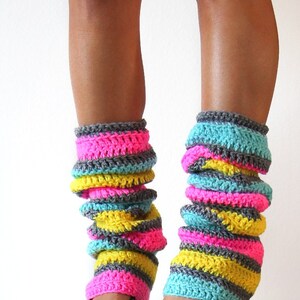 May include: A pair of colorful striped leg warmers in pink, yellow, blue, and gray. The leg warmers are crocheted and are worn with black high-heeled shoes.