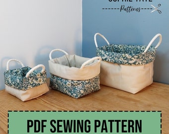 May include: Three different sized storage baskets with white rope handles and a floral fabric lining. The baskets are on a wooden surface. The text "Sophie Tate Patterns" is in the top right corner of the image. The text "PDF Sewing Pattern" is in a green rectangle at the bottom of the image.