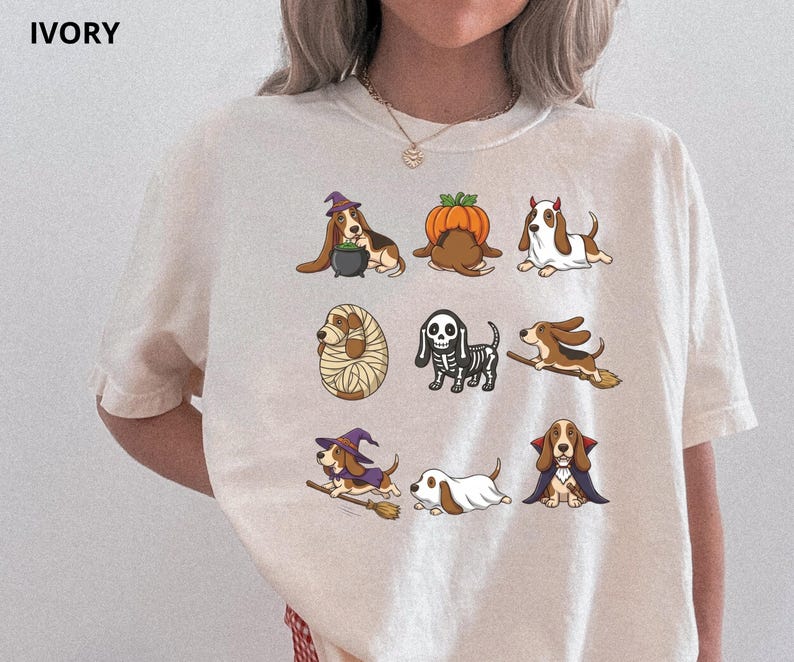Pu&ograve; includere: Una t-shirt color avorio con una stampa grafica di nove basset hound in vari costumi di Halloween, tra cui una strega, una zucca, un fantasma, una mummia, uno scheletro, un cavaliere su scopa e un vampiro, con la parola IVORY stampata nell'angolo.