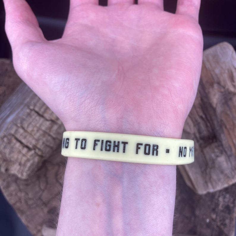 Pu&ograve; includere: Un braccialetto in silicone giallo con il testo "ING TO FIGHT FOR - NO M"
