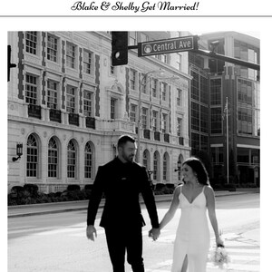 May include: A black and white photo of a couple walking hand-in-hand down a city street. The bride is wearing a white dress and the groom is wearing a suit. The street sign reads "Central Ave."