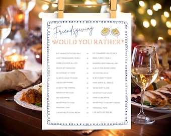 May include: A Friendsgiving-themed game card with a blue border, held by wooden clips. The card features the text "Friendsgiving Would You Rather?" and a list of humorous choices, perfect for a holiday gathering. The background shows a festive table setting.