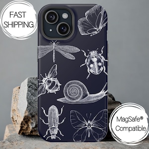 May include: A navy blue phone case featuring white line drawings of various insects, including a butterfly, dragonfly, and beetle. The case has a glossy finish and is designed for a smartphone. The words "Fast Shipping" and "MagSafe Compatible" are also visible.