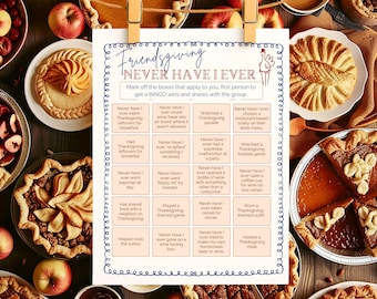 May include: A festive Friendsgiving game card, "Never Have I Ever," hangs with a clothes pin. Surrounded by pies, apples, and other Thanksgiving treats. The game features a list of fun prompts for a holiday gathering.