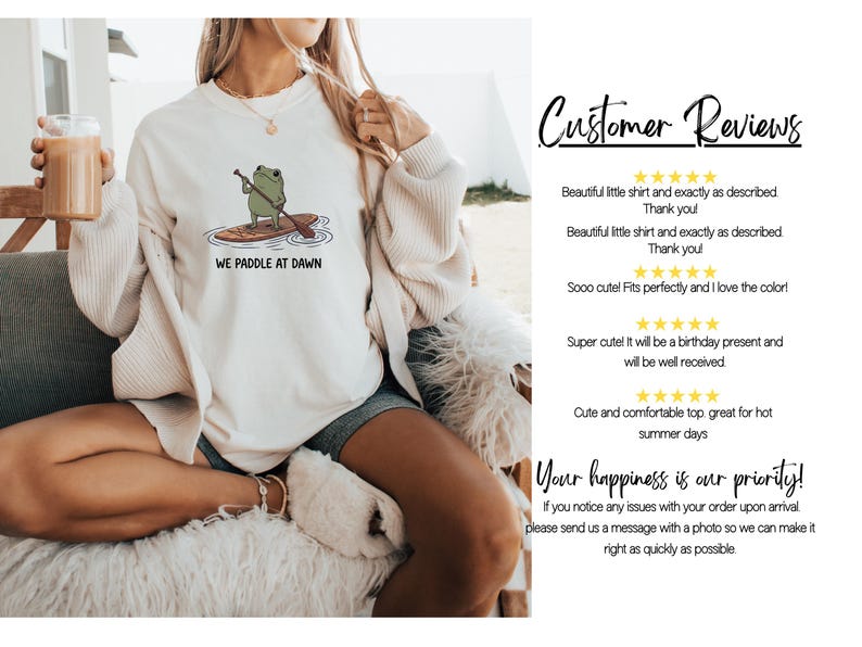 Pu&ograve; includere: Una felpa girocollo color crema con la grafica di una rana verde su una tavola da paddle e il testo "WE PADDLE AT DAWN". A destra, una sezione intitolata "Customer Reviews" mostra valutazioni a cinque stelle e commenti testuali.