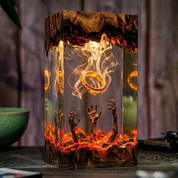A hand-crafted resin diorama lamp encasing a dark mythical ring of flame — part desk lamp, part tiny fantasy world you can stare into.