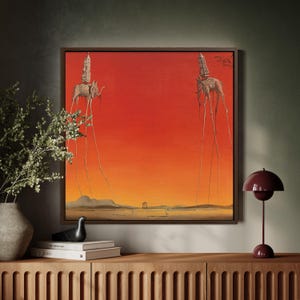 Könnte beinhalten: Gerahmtes surrealistisches Gemälde mit zwei elefantenartigen Kreaturen mit langen Beinen, die jeweils eine Struktur tragen. Das Kunstwerk ist vor einem leuchtend roten und orangen Himmel mit einem fernen Landschaftshintergrund angeordnet.