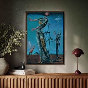 May include: A framed surrealist painting with a blue sky background. The artwork features a tall, elongated figure with open arms, a giraffe, and other abstract forms. The painting is displayed above a wooden cabinet.
