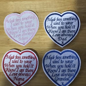 May include: Four heart-shaped embroidered patches with the text "Made from something I used to wear When you hold it Know I am there Love always" and personalized names: Mum, Dad, Nana, and Grandad. Each patch has a different color border and text.