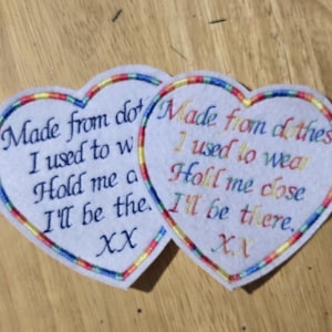 May include: Two heart-shaped patches with embroidered text and rainbow trim. The text reads "Made from clothes I used to wear. Hold me close, I'll be there. XX."