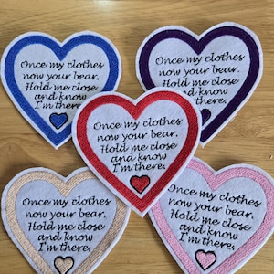 May include: Five heart-shaped embroidered patches with the text: "Once my clothes now your bear, Hold me close and know I'm there." The patches have borders in blue, purple, red, gold, and pink. Each has a small heart.