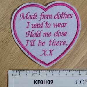 May include: Pink heart-shaped patch with white felt and pink stitching. The patch says "Made from clothes I used to wear Hold me close I'll be there. XX".