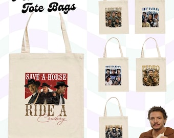 May include: Cream-coloured tote bags featuring images of Pedro Pascal. One bag has the text "SAVE A HORSE RIDE A Cowboy". Other bags display images and text related to his roles. The bags have long handles.