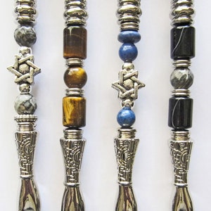 May include: Four silver-toned, hand-shaped, decorative writing implements with a star of David charm and various gemstone beads. The beads include gray, brown, blue, and black.