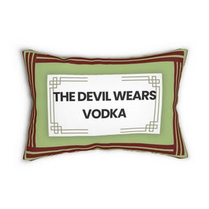 May include: Rectangular decorative pillow with a light green background and a burgundy border. The pillow features the text "THE DEVIL WEARS VODKA" in black, within a white and gray rectangular frame. A fun and quirky home decor item.