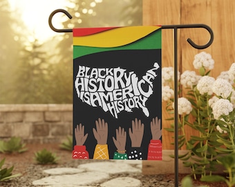 Puede incluir: Una bandera de jardín negra y verde con el texto "Black History is American History" en letras blancas dentro del contorno de los Estados Unidos. La bandera tiene una franja roja, amarilla y verde en la parte superior. Hay manos levantadas de diferentes tonos de piel en la parte inferior de la bandera.