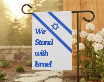 May include: A white garden flag with blue stripes and a Star of David. The flag reads "We Stand with Israel".