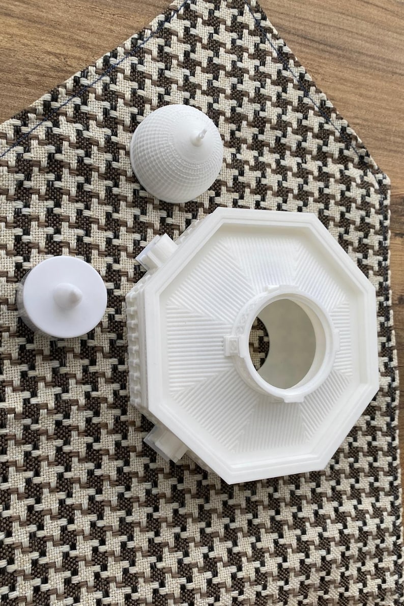 May include: White 3D printed model of a building with a domed roof. The model is in three pieces, the base, the dome, and a small circular piece.
