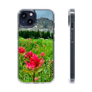 May include: A clear phone case with a colorful image of a mountain range and wildflowers. The case is designed to fit an iPhone.