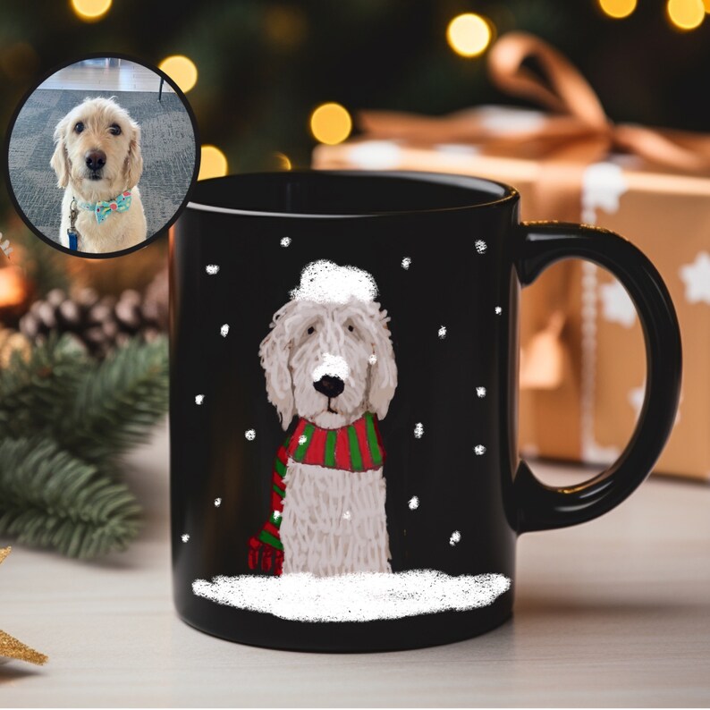 May include: Black coffee mug with a white dog wearing a red and green scarf in a snowy scene. The dog is wearing a white Santa hat.