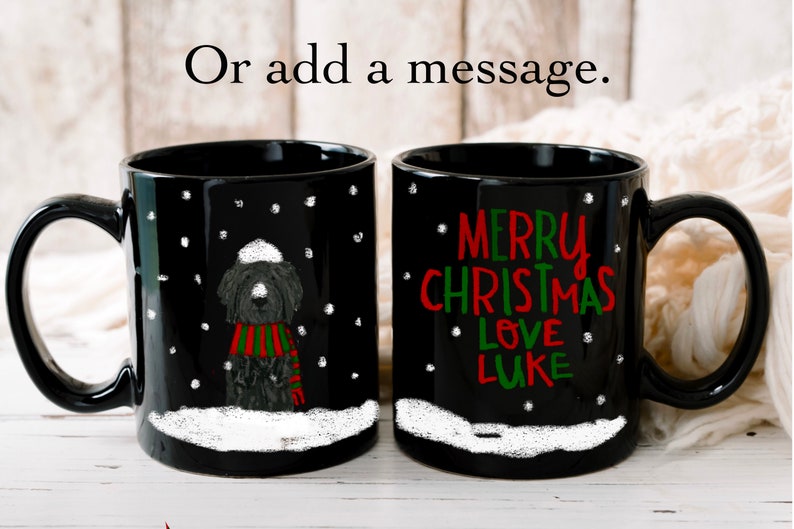 May include: Two black coffee mugs with white snow and snowflakes. One mug has a black and white illustration of a dog wearing a red and green scarf and a white hat. The other mug has the text "Merry Christmas Love Luke" in red and green.