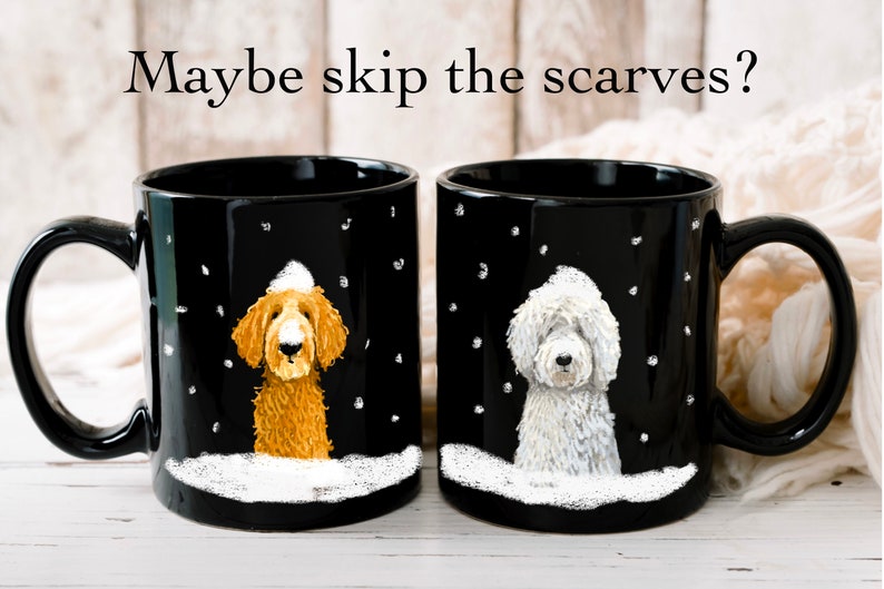 May include: Two black coffee mugs with white snow and snowflakes on them. Each mug features a dog wearing a white hat. One dog is brown and the other is white.
