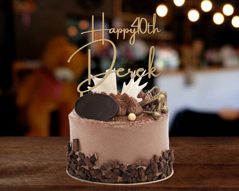 happy 40th Derek personalized gold wood birthday cake topper on a decorated chocolate cake