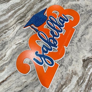 Potts Upscaled Designs Deluxe Grad Sign in White Orange and Blue Glitter