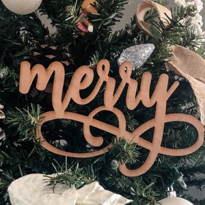 May include: A wooden Christmas tree topper with the word "merry" written in cursive.