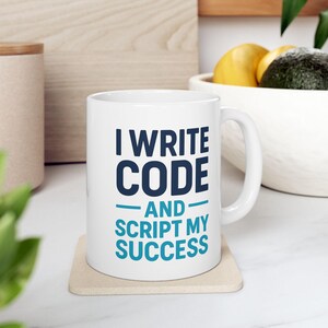 May include: White ceramic mug with a blue and white design. The mug says "I write code and script my success".