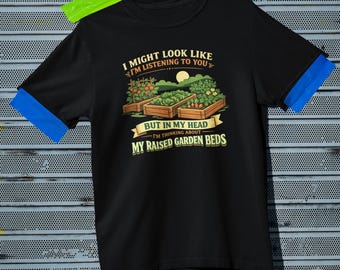 May include: Black t-shirt with the text "I might look like I'm listening to you but in my head I'm thinking about my raised garden beds." The graphic shows three raised garden beds with plants and a sun.