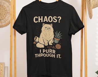 May include: Black t-shirt with a graphic of a fluffy cat, a potted plant, and a ball of yarn. The text reads "CHAOS? I PURR THROUGH IT."