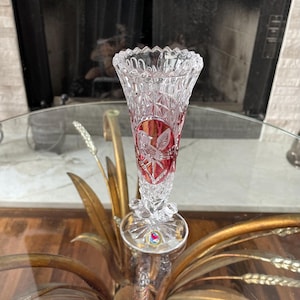 May include: A white ceramic mug with a black handle and the text "But First, Coffee" in a black, bold font. The mug is on a white surface.