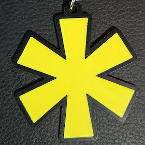 May include: A yellow asterisk keychain with a silver chain and a silver ring.
