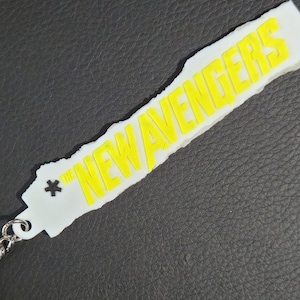 May include: White keychain with a yellow "*THE NEW AVENGERS" text.