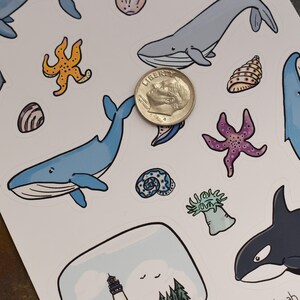 May include: A sheet of stickers featuring various ocean-themed illustrations, including whales, starfish, seashells, and a lighthouse. The stickers are printed on white paper and are perfect for adding a touch of whimsy to any project.