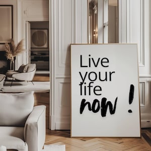 Puede incluir: Un póster motivacional en blanco y negro con el texto "Live your life now!" impreso en una fuente en negrita y con trazos de pincel.