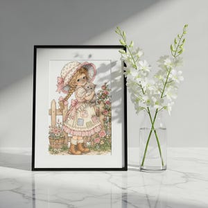 May include: A framed print featuring a drawing of a young person with blonde braided hair wearing a bonnet and a patchwork dress, holding a small kitten. The scene includes a wooden fence, pink roses, and a potted plant in a garden setting.