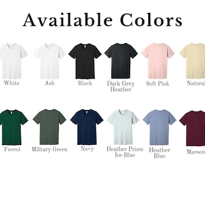 Puede incluir: Un gr&aacute;fico que muestra 12 colores de camiseta diferentes, incluyendo blanco, ceniza, negro, gris oscuro jaspeado, rosa suave, natural, bosque, verde militar, azul marino, azul hielo jaspeado, azul jaspeado y granate.