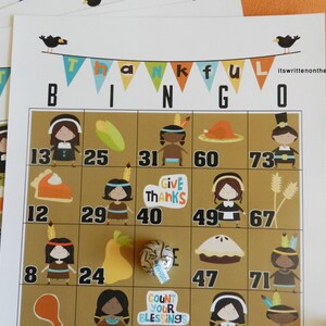 Może przedstawiać: Karty do bingo o tematyce Święta Dziękczynienia z kolorowymi ilustracjami pielgrzym&oacute;w, rdzennych Amerykan&oacute;w i jedzenia. Słowo "THANKFUL" jest wyświetlane u g&oacute;ry. Karty mają liczby i obrazy.