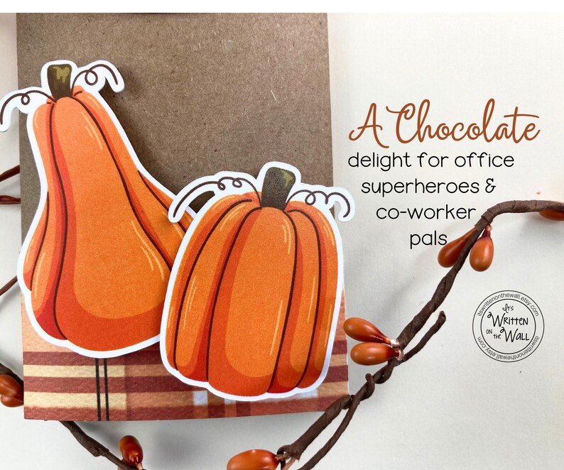 May include: A card with a handwritten message that reads "A Chocolate delight for office superheroes & co-worker pals". The card features two orange pumpkins with white outlines.