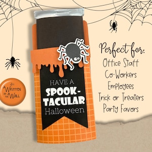 Może przedstawiać: Uchwyt na prezent o tematyce Halloween w kolorach pomarańczowym i czarnym. Uchwyt posiada czarny baner z napisem "HAVE A SPOOK-TACULAR Halloween" w kolorze białym. Do uchwytu przymocowany jest dekoracyjny pająk.