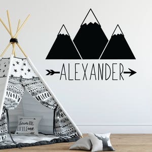 May include: Black and white mountain silhouette wall decal with the name "ALEXANDER" and an arrow pointing to the right.