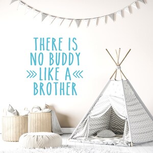 May include: A white teepee tent with a gray and white chevron pattern. The tent is set up in a room with a white rug and a white wall. The wall has a blue and white wall decal that reads "There is no buddy like a brother".