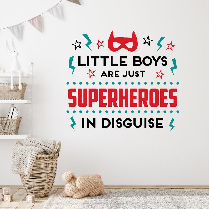 May include: A wall decal with the text "Little boys are just superheroes in disguise". The text is in black, red, and teal with a red superhero mask graphic above the text.
